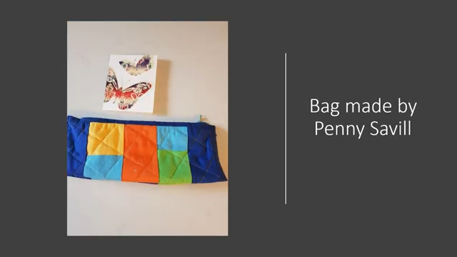 A blue zipper pouch with a patchwork design in yellow, orange, green, and blue. Next to it is a small card with an image of a butterfly.