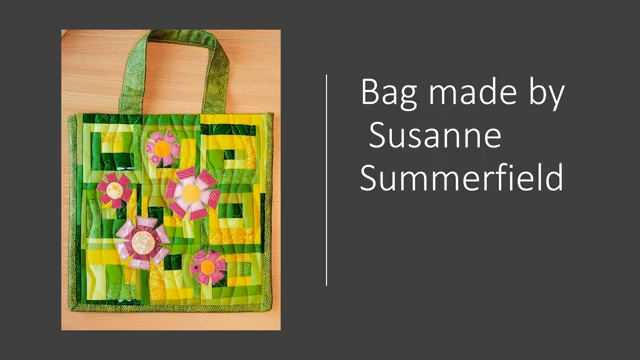 A green tote bag with a patchwork design featuring colourful flowers. The bag has a green handle