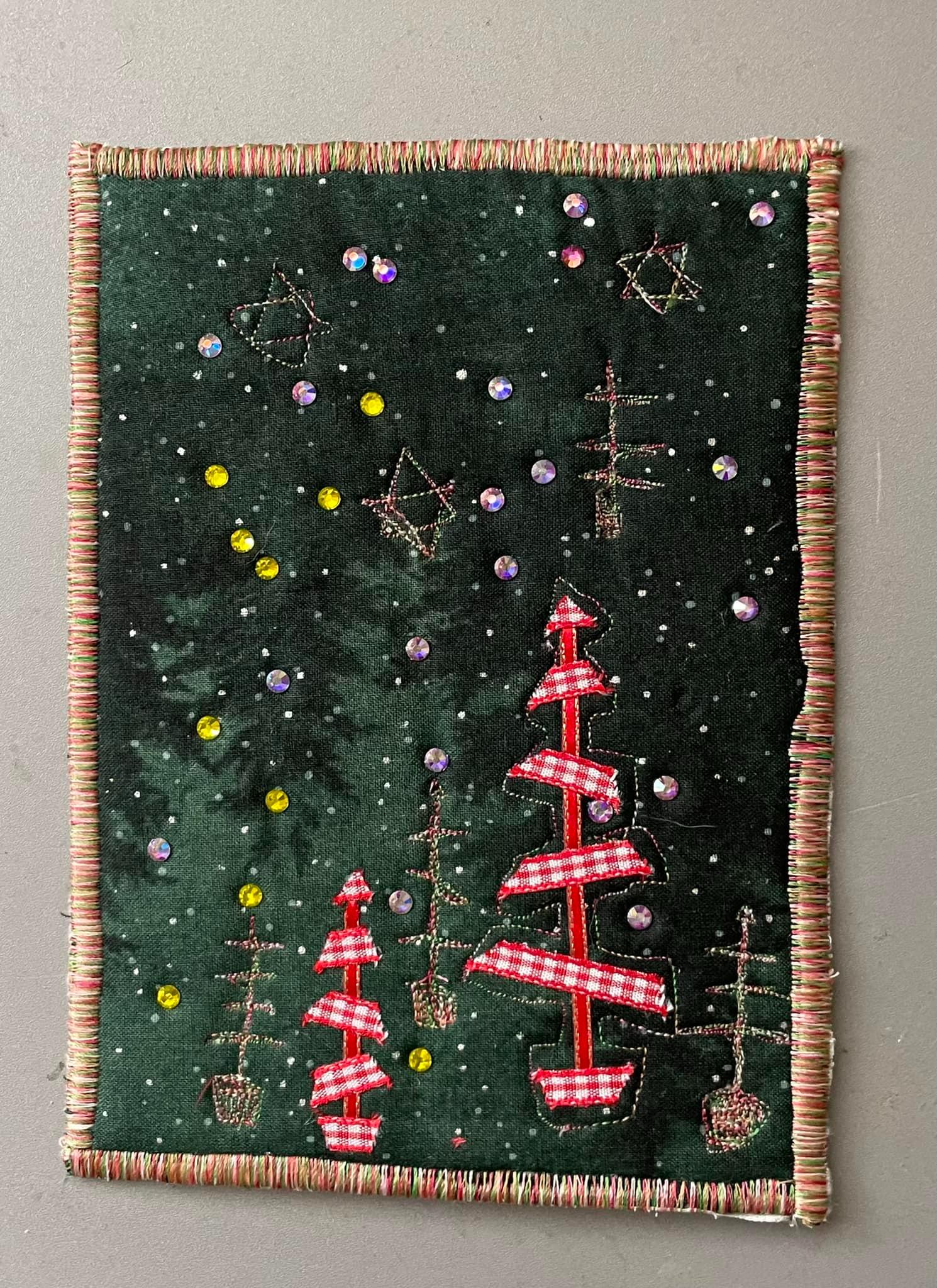 A square quilt with a dark green background. The quilt features multiple Christmas trees of varying sizes, some adorned with red and white striped fabric. There are also stars and other decorative elements scattered across the background.