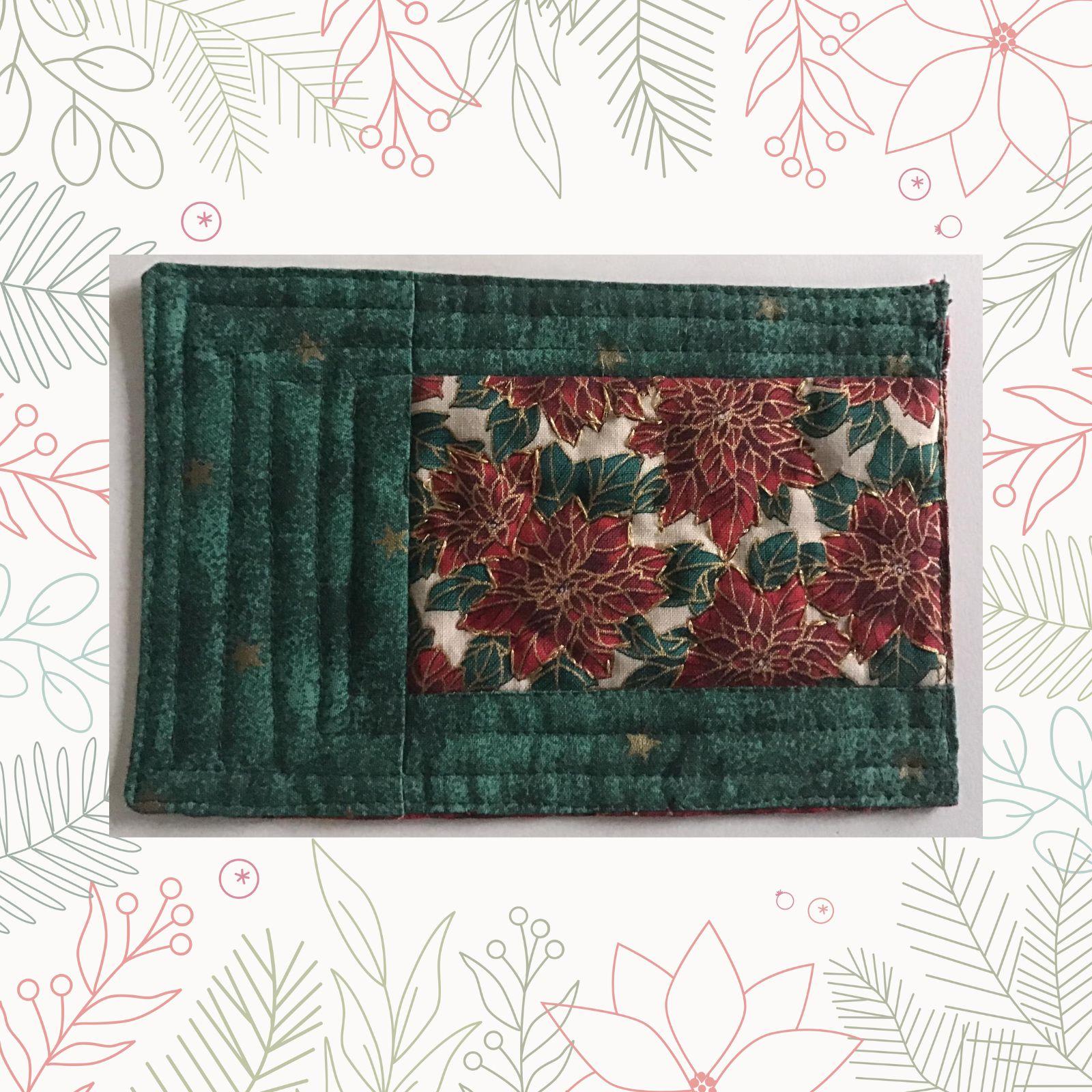 A rectangular quilt with a green background and a red border. The quilt features a central panel with a floral pattern in red and gold, surrounded by green fabric. The background is quilted with a linear pattern.