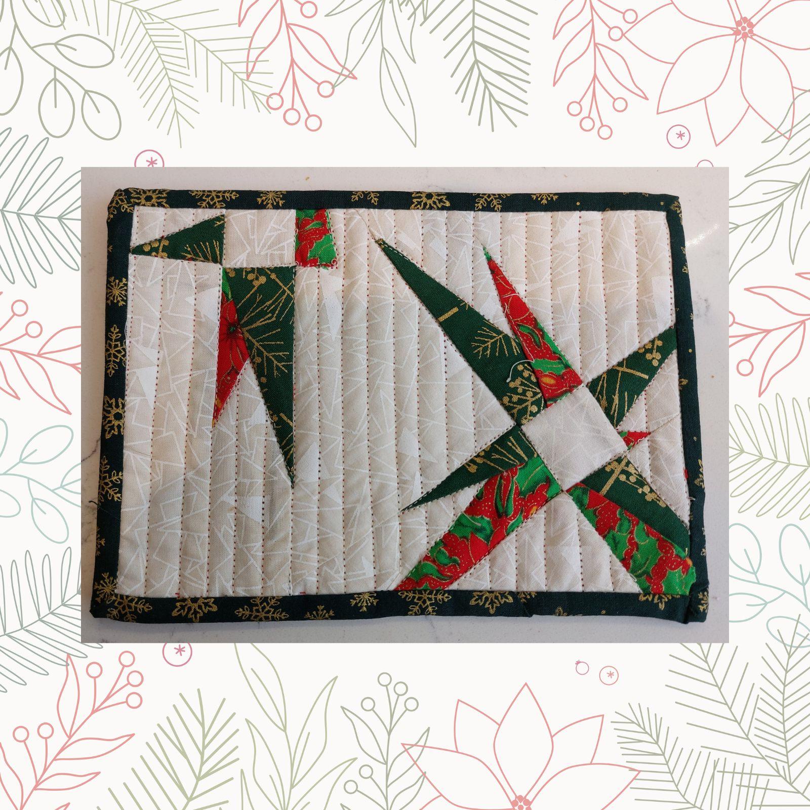 A rectangular quilt with a white background and a red border. The quilt features two star-shaped designs, one in red and one in green. The stars are made up of smaller triangles and have a textured, quilted appearance. The background is quilted with a linear pattern.