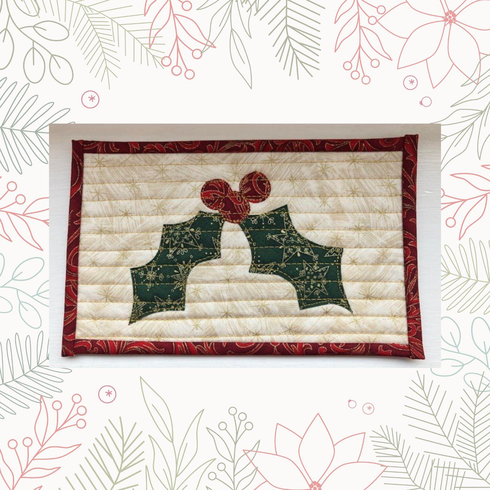 A rectangular quilt with a white background and a red border. The quilt features a green holly leaf with red berries, embroidered with gold thread. The background is quilted with a linear pattern.