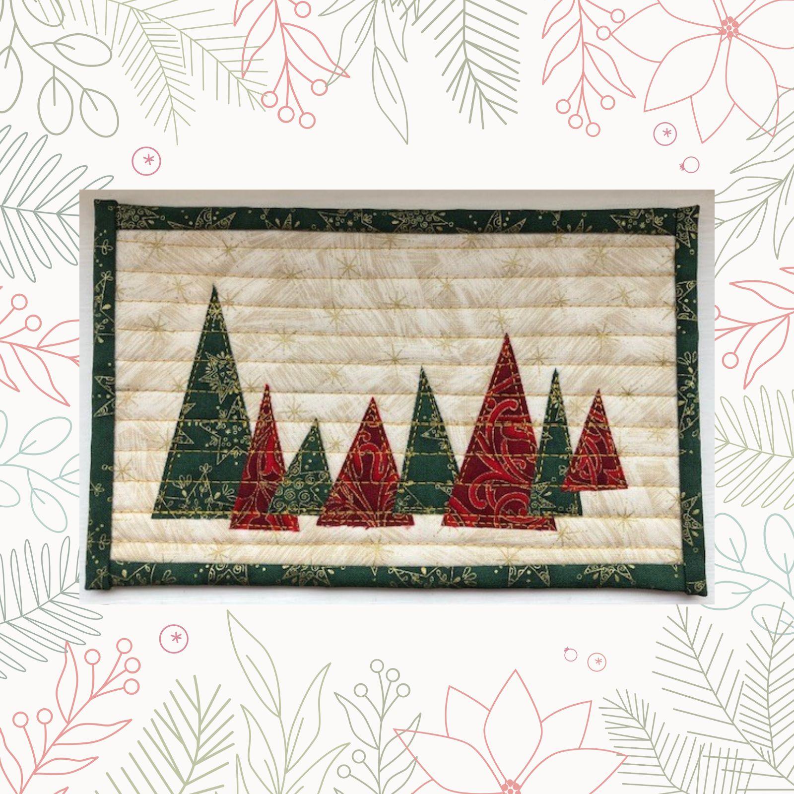 A rectangular quilt with a white background and a green border. The quilt features a row of Christmas trees in various sizes, made from green and red fabric with gold accents. The background is quilted with a linear pattern.