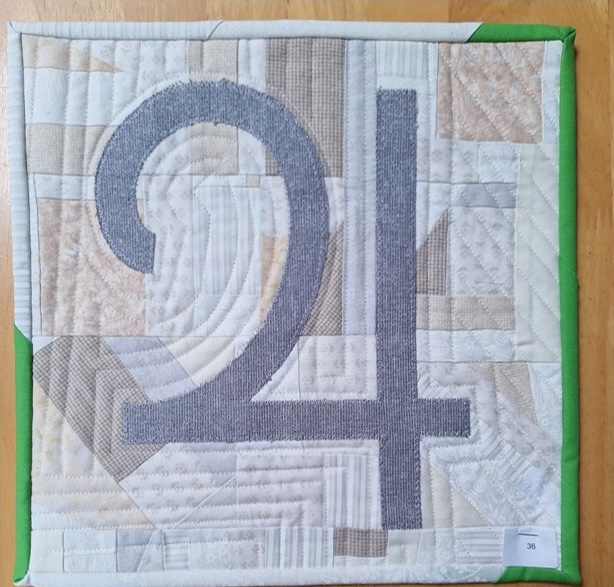 A square quilt with a white background and a green border. The quilt features the number "24" in gray, with a patchwork background in various shades of beige and white. The background is quilted with different patterns, including linear and curved lines. The quilt is bound with green binding.