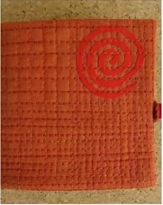 A red quilted needle case with a circular design in the top right corner. The design features concentric circles in a darker shade of red. The case has a quilted texture and a red ribbon tie.