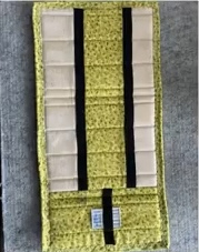 A yellow quilted needle case with black straps. The case has multiple pockets for storing needles and other sewing tools.