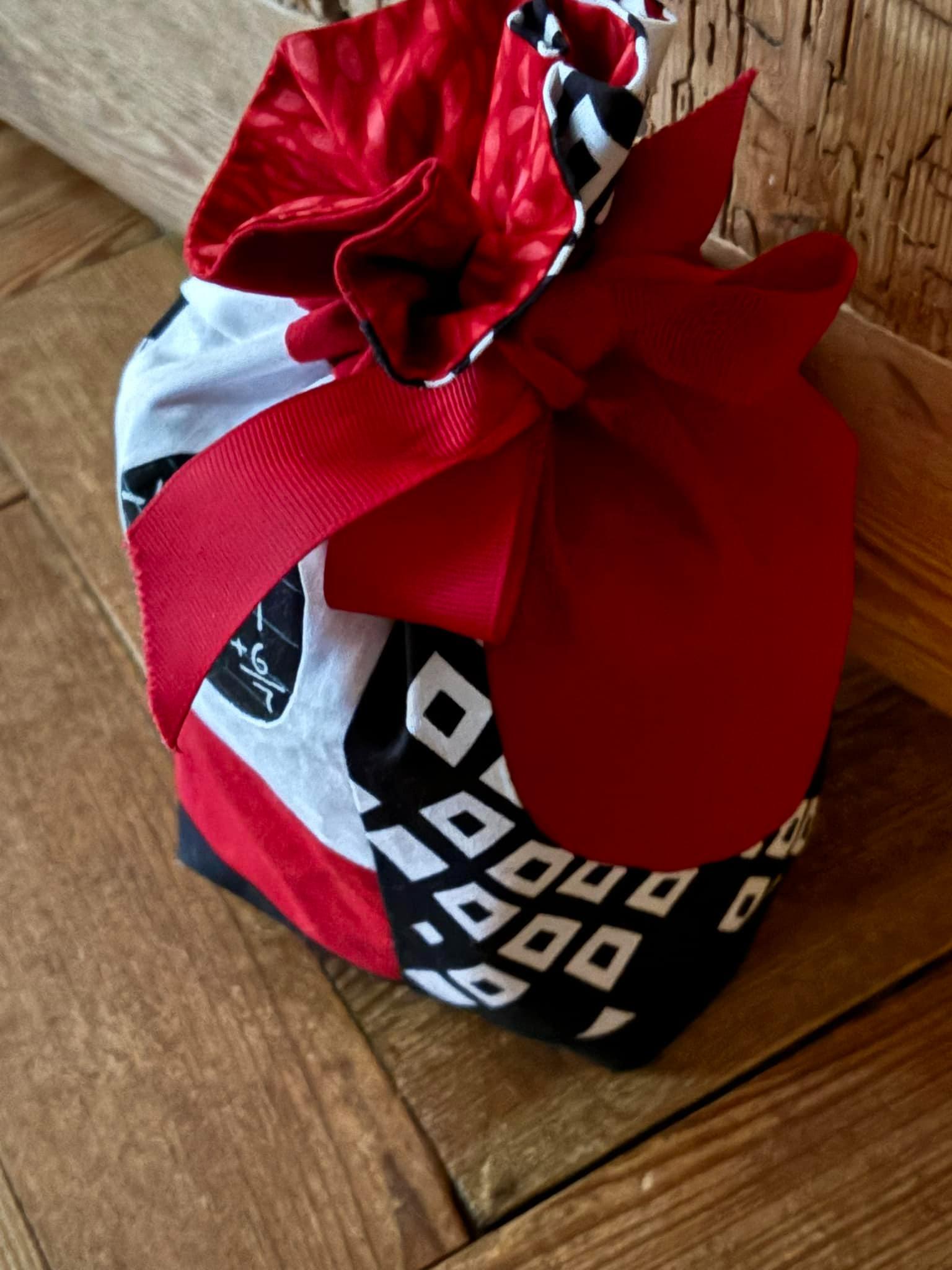 Patchwork doorstop made in red white and black fabric. A ribbon secures the top.