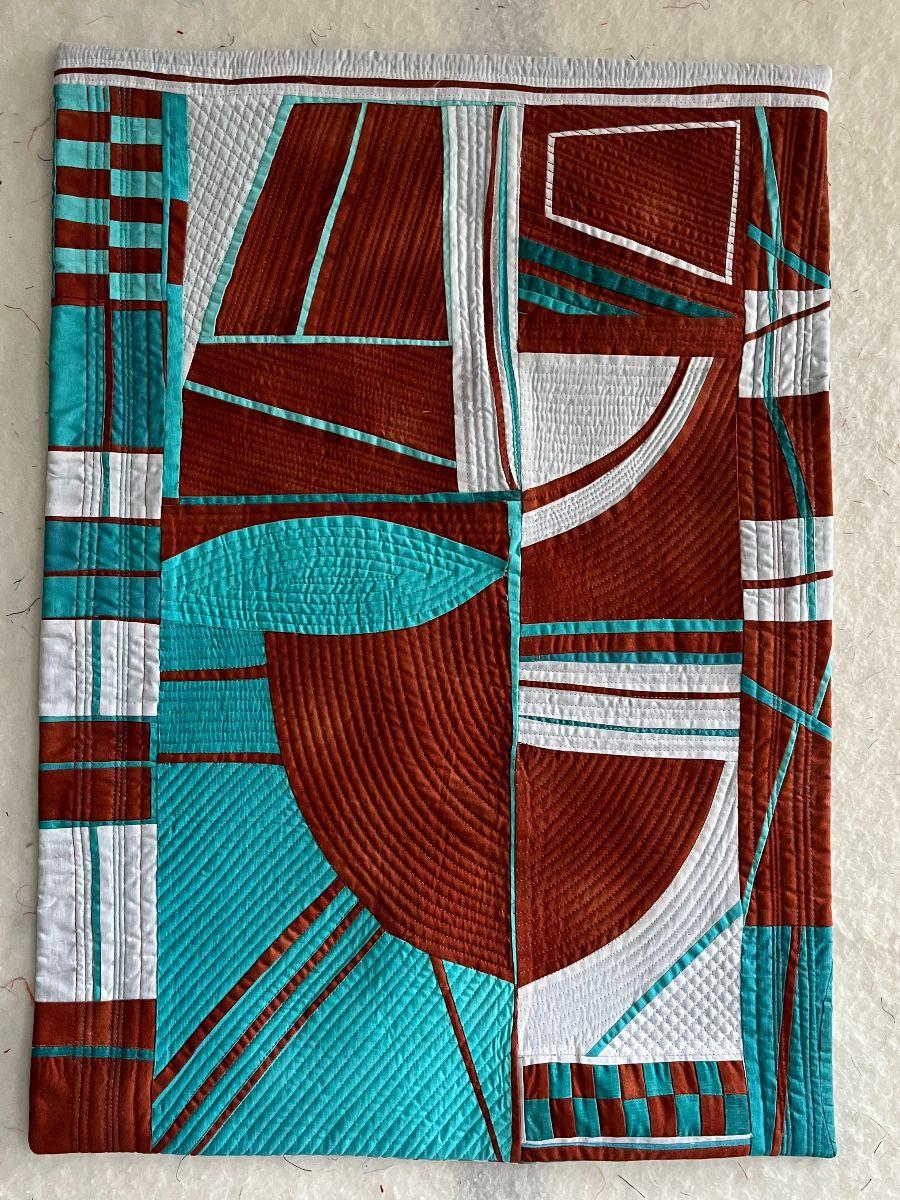 Modern abstract quilt featuring geometric shapes in teal, brown, and white, with contrasting quilting patterns.