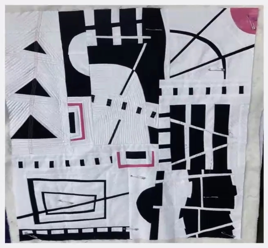 Improv quilt piece in the style of Irene Roderick dancing with the wall in black and white with shots of bright pink