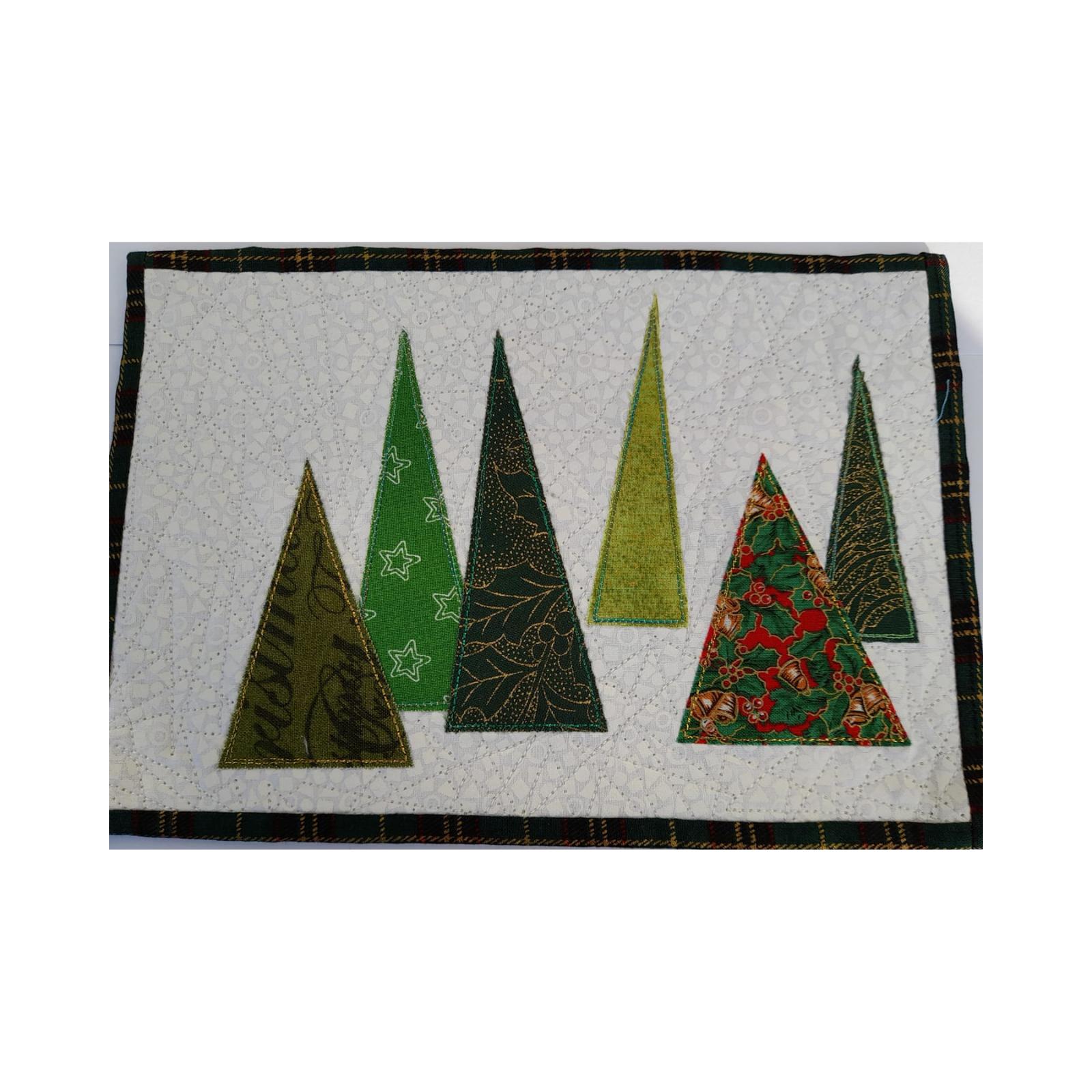 A rectangular quilt with a plaid border. The quilt features multiple Christmas trees of various sizes and patterns, all in shades of green. The background is a white fabric with a subtle, linear quilting pattern.