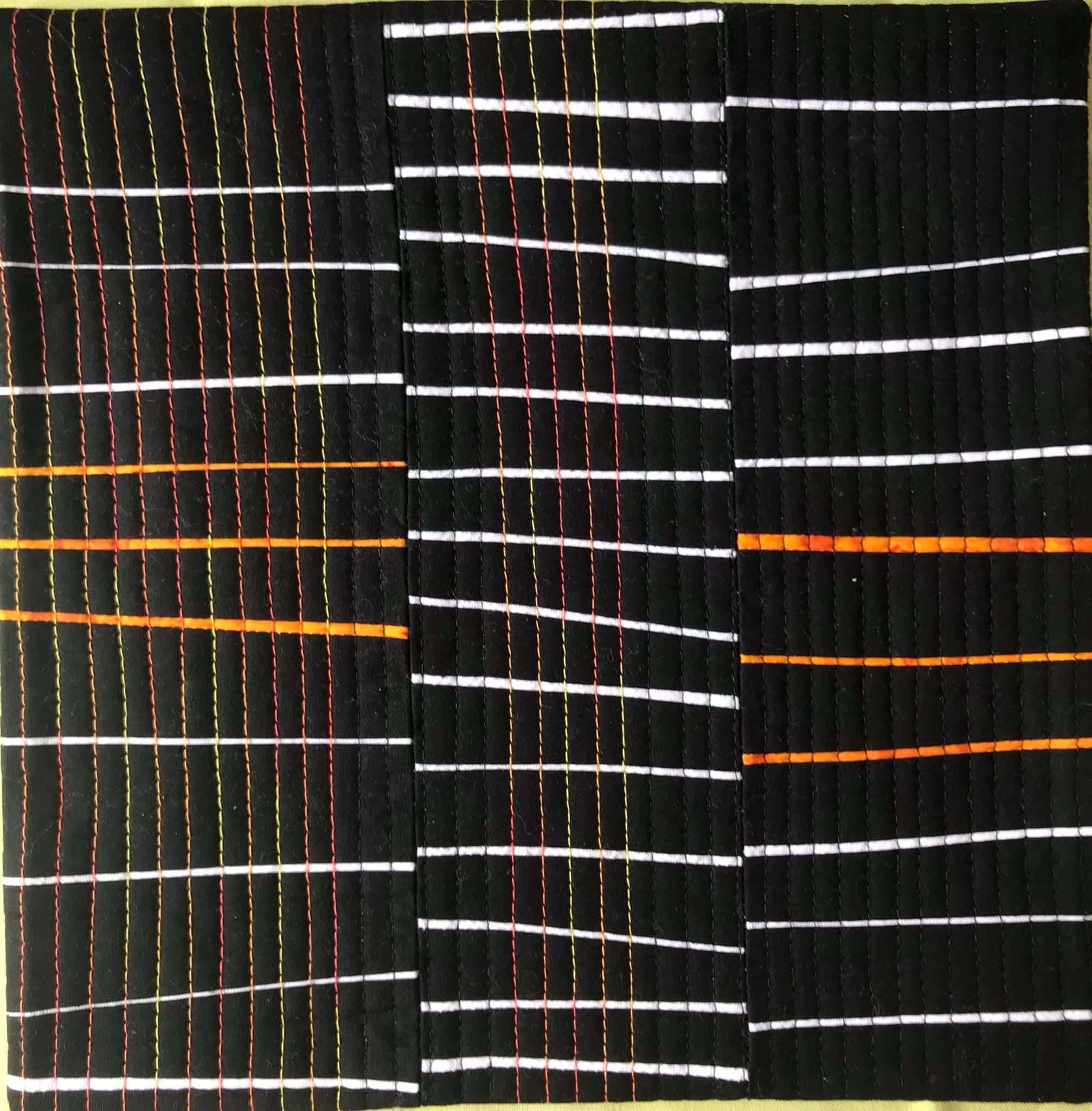A rectangular quilt with a black background and three vertical sections. Each section features a different pattern of white and orange stitching. The left section has horizontal and vertical orange lines, the middle section has horizontal white lines, and the right section has horizontal orange lines.