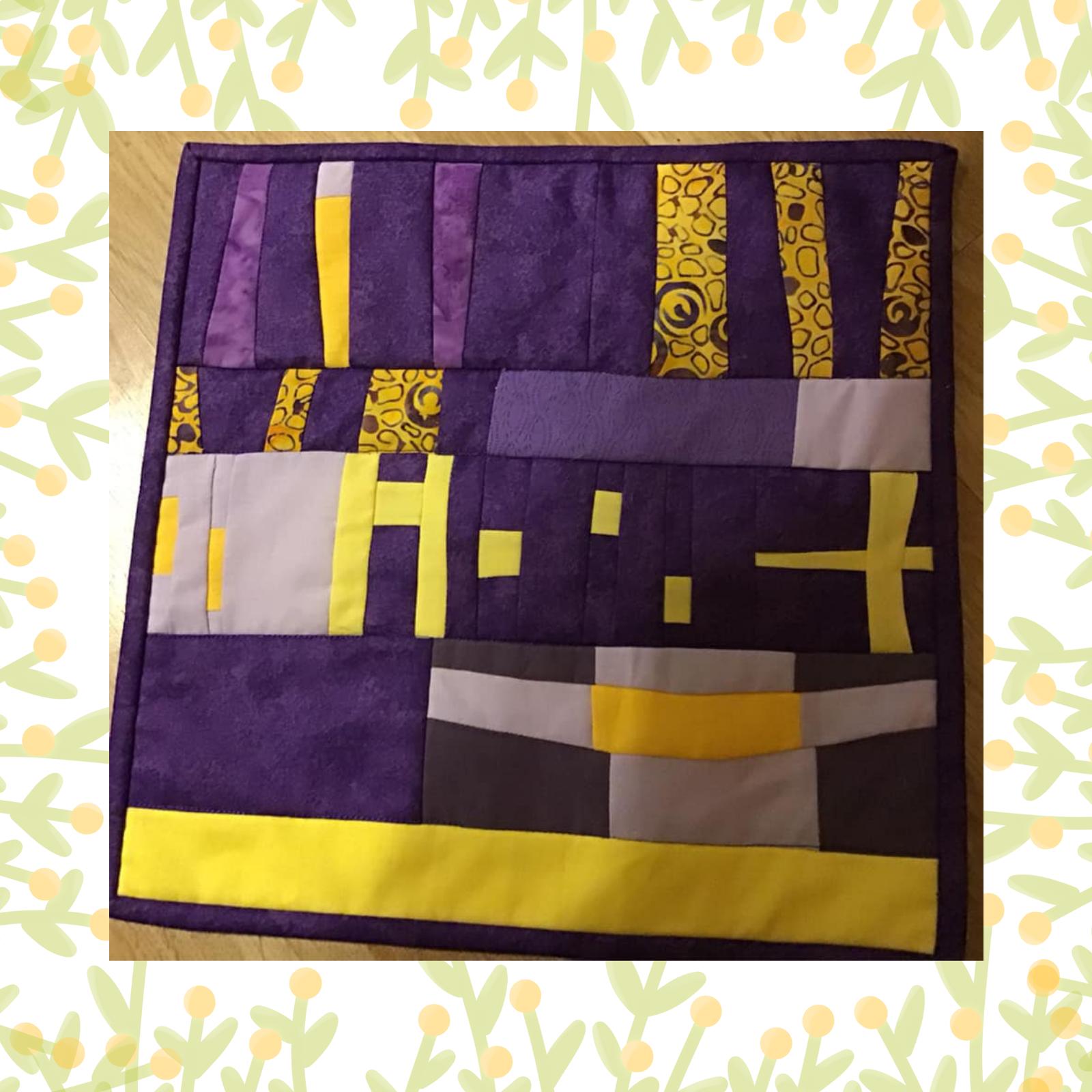 A square quilt with a purple background and a yellow border. The quilt features a geometric design with vertical and horizontal strips of purple and yellow fabric, with some squares and rectangles added for visual interest. The background is quilted with a linear pattern.