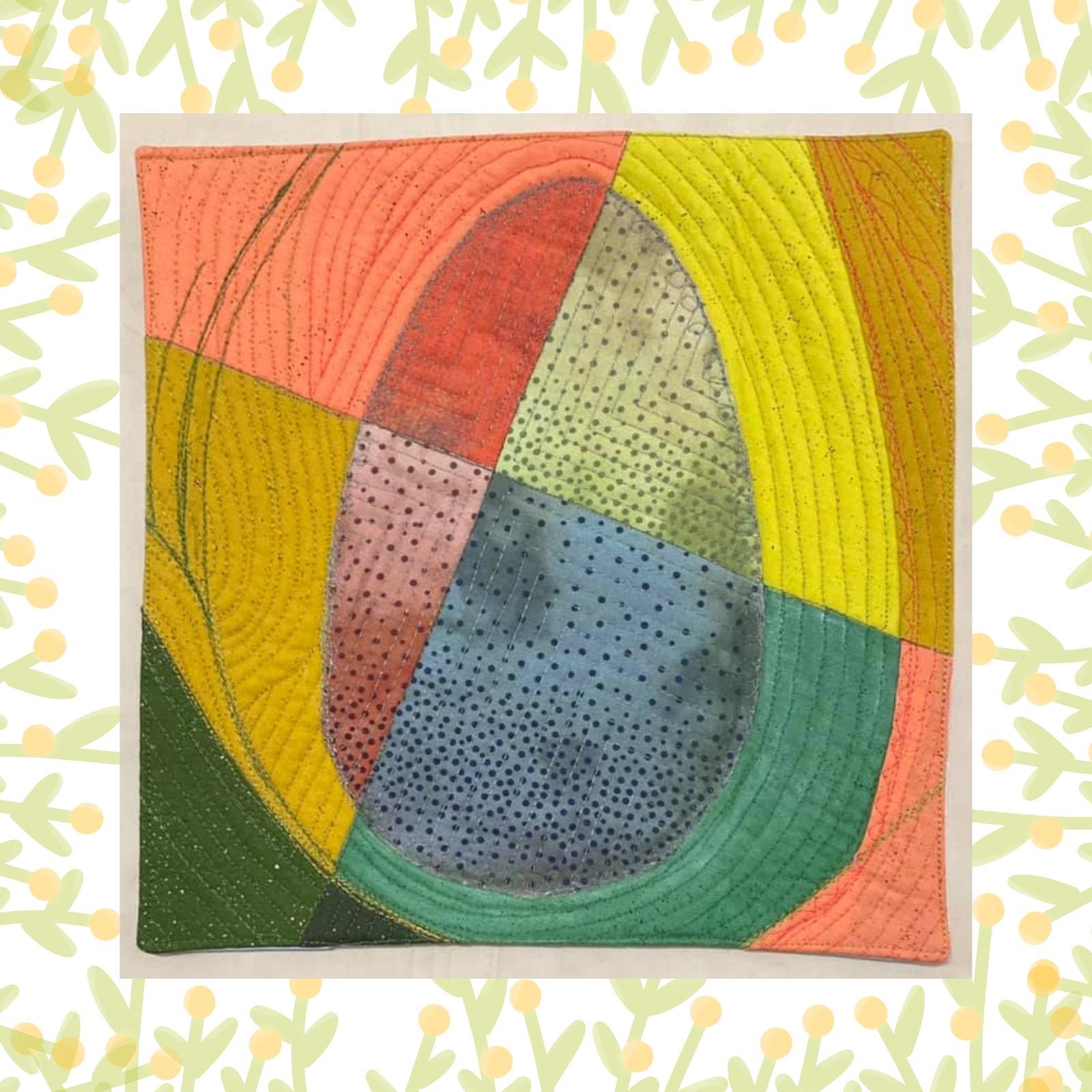 A square quilt with a colourful, abstract design. The quilt is divided into four sections, each with a different colour: orange, yellow, green, and blue. In the centre, there is an oval shape with a textured pattern. The background is quilted with curved lines.