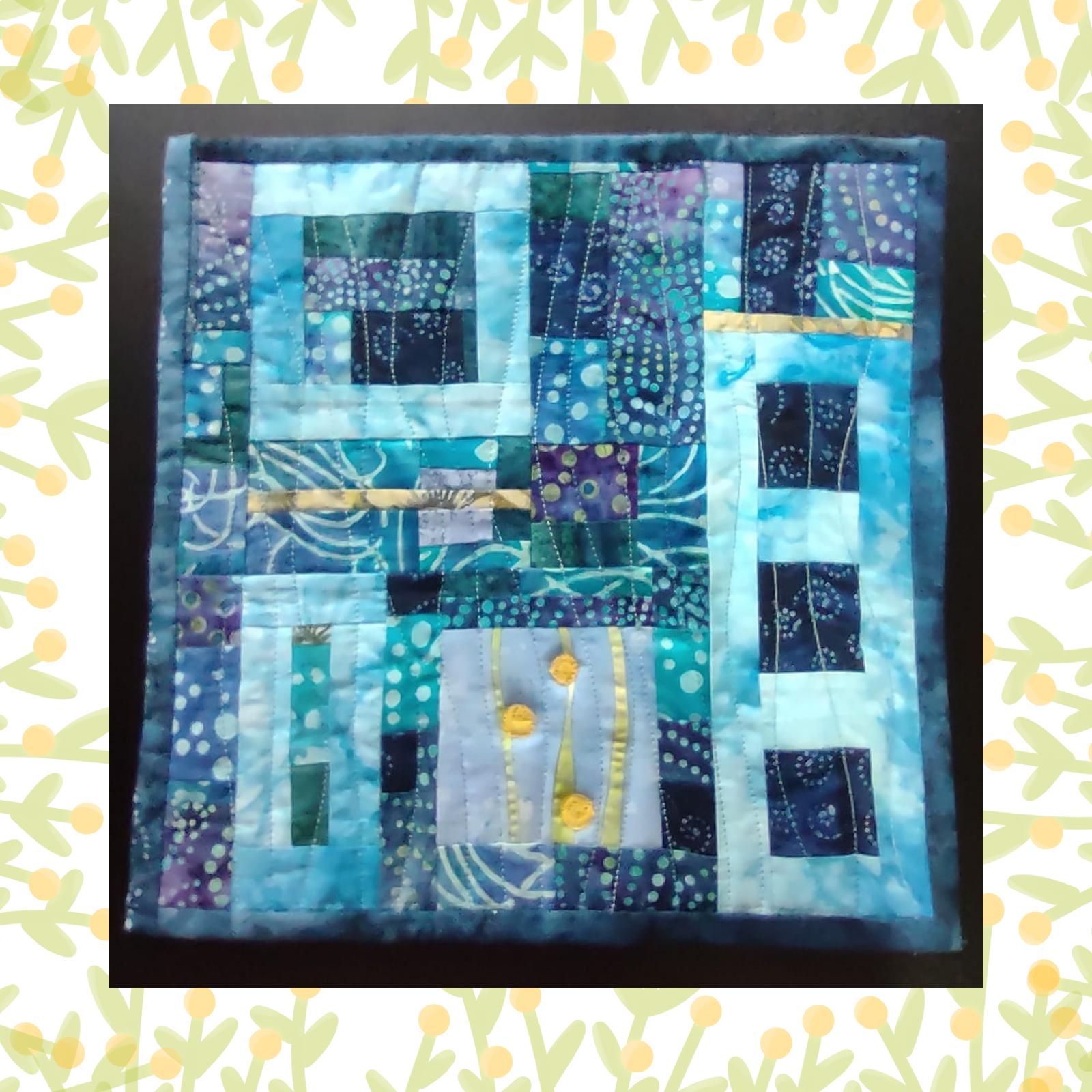 A square quilt with a blue background and a blue border. The quilt features a patchwork design with squares and rectangles in various shades of blue and purple. There are also some thin strips of gold fabric adding a touch of shimmer. The background is quilted with a linear pattern.