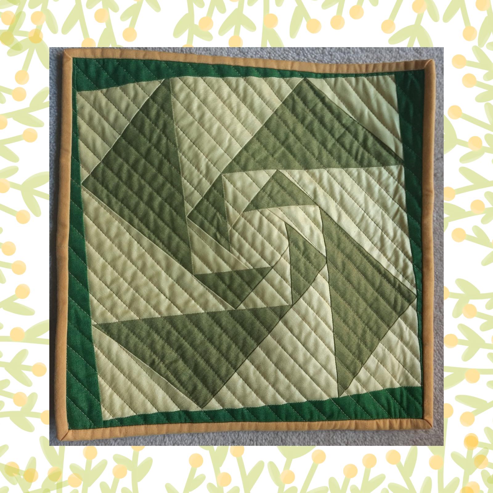 A square quilt with a green and brown colour scheme. The quilt features a swirling, geometric design made up of triangles in varying shades of green. The background is quilted with a linear pattern. The quilt is framed by a brown border.