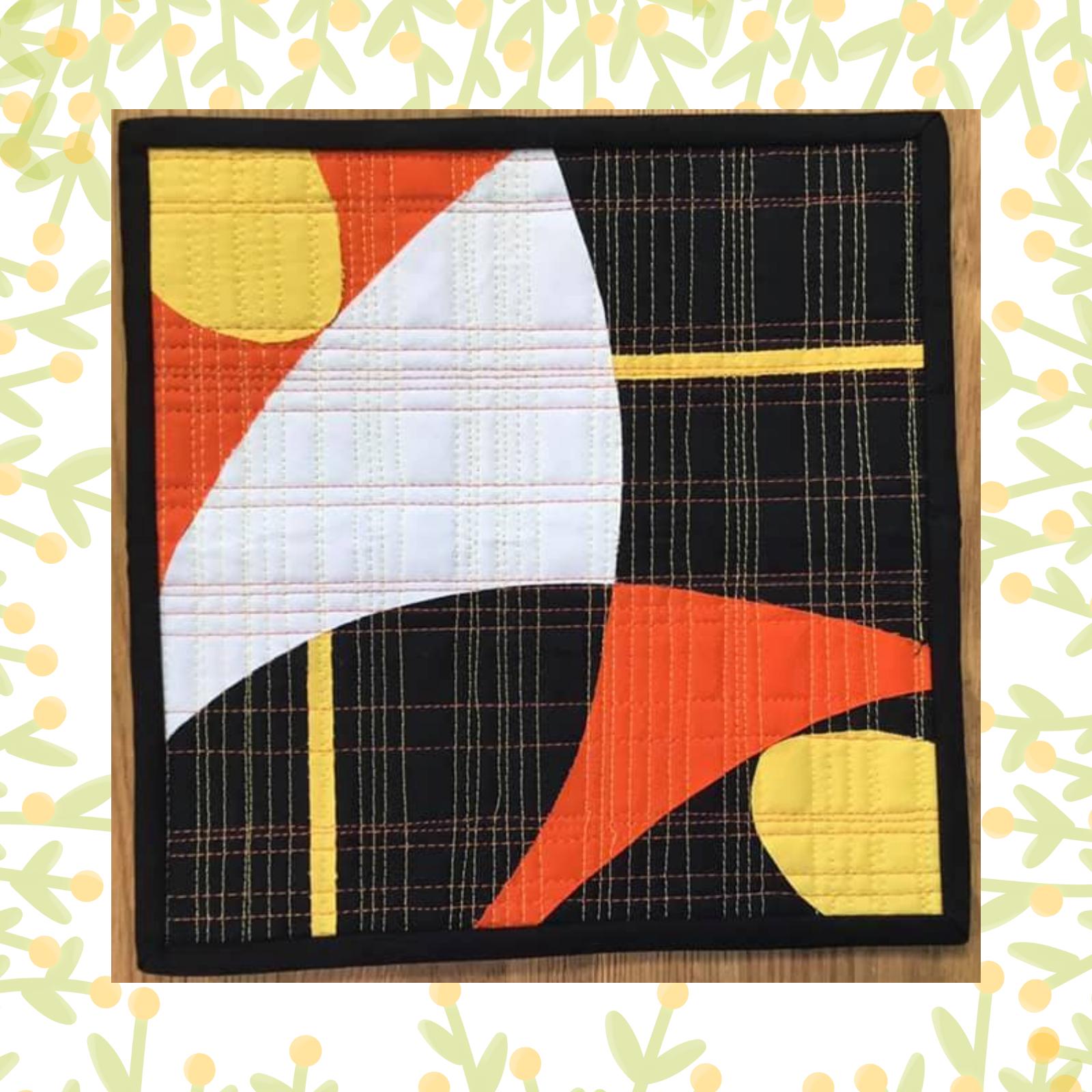 A square quilt with a black background and a black border. The quilt features a colourful, abstract design with shapes in white, yellow, orange, and red. The background is quilted with a grid pattern.