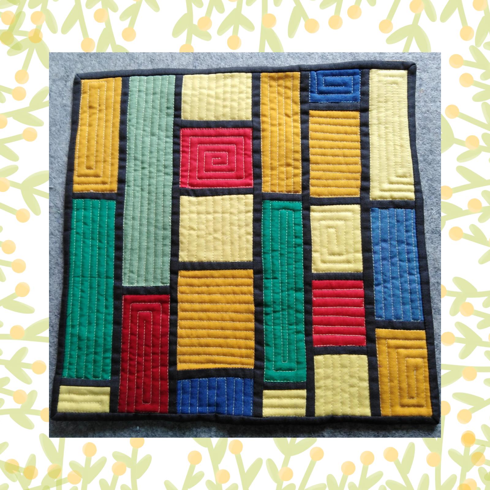 A square quilt with a black background and a black border. The quilt features a colourful, geometric design with rectangles in various colours, including red, yellow, green, and blue. Some of the rectangles have a spiral pattern, while others have a vertical quilting pattern. The background is quilted with a linear pattern. Other rectangles have a vertical or horizontal quilting pattern.