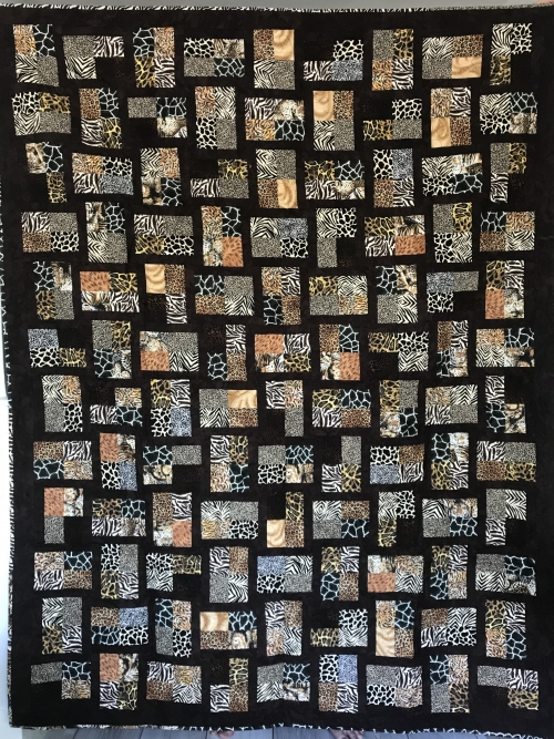 Quilt with black background and blocks of different animal print fabric by Adelle Lindsay