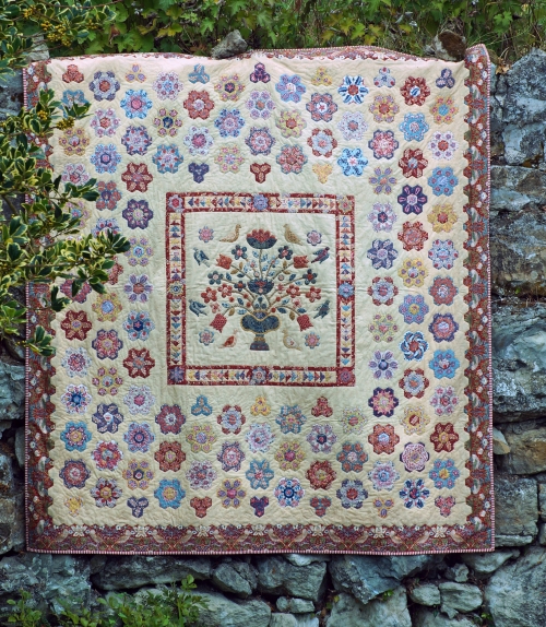 Quilt made of hexagonal flower shapes in various patterned fabrics by Elizabeth Bowen.