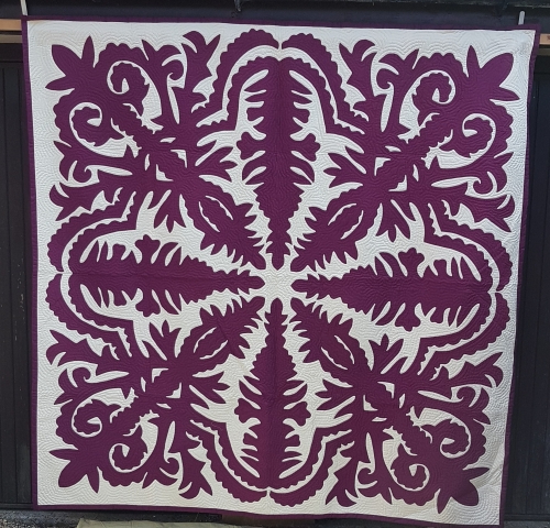 Quilt by Pippa Moss. Purple damask style pattern on white background
