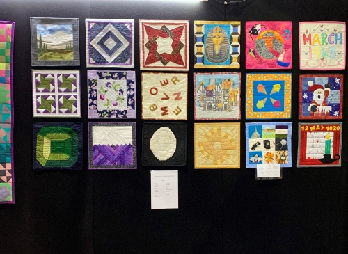 A selection of quilts displayed on an exhibition stand