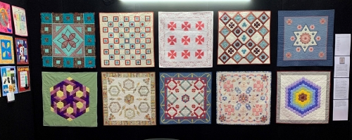 A selection of quilts displayed on an exhibition stand