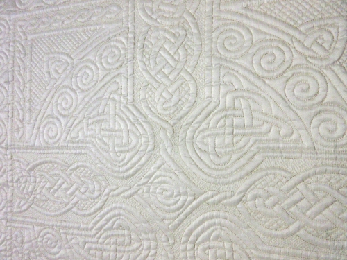 Close up of embroidered pattern in white quilt