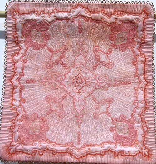 Square pink quilt with embroidered detail